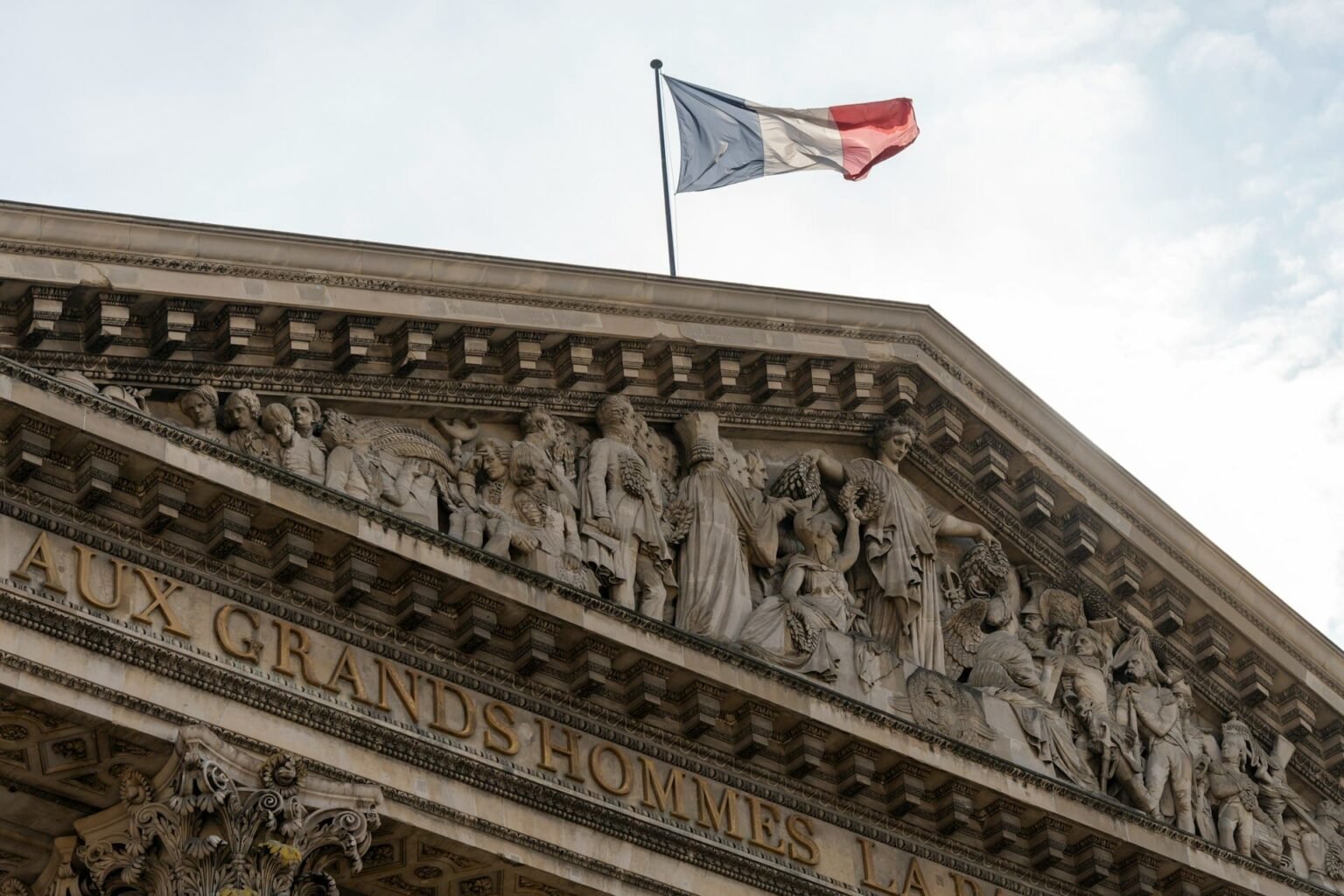 Advérbios (adverbes) em francês Frontão do Panthéon de Paris, com a inscrição "Aux grands hommes" e a bandeira da França