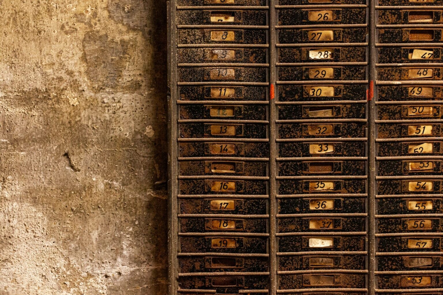 Fileiras de antigos compartimentos de metal com plaquinhas numeradas