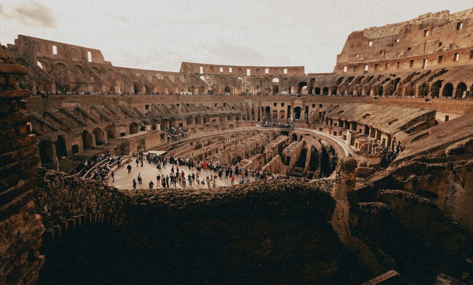 Interior do Coliseu, em Roma, com turistas na arena