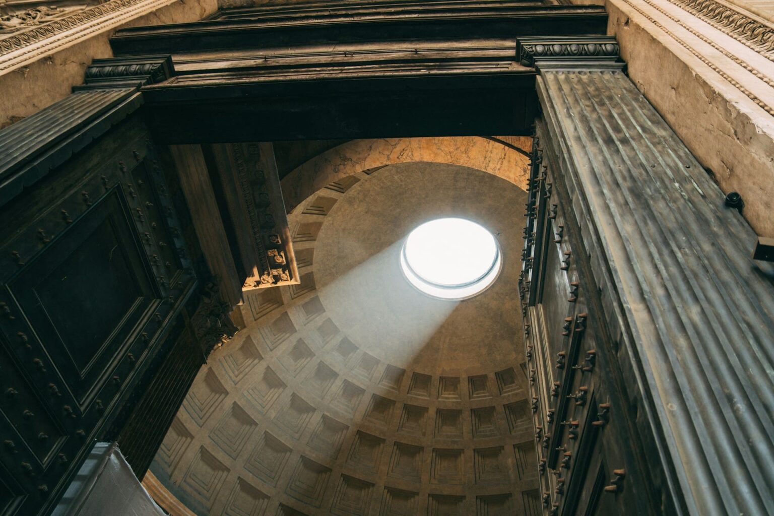Luz entrando pelo óculo da cúpula do Panteão, em Roma, vista da porta