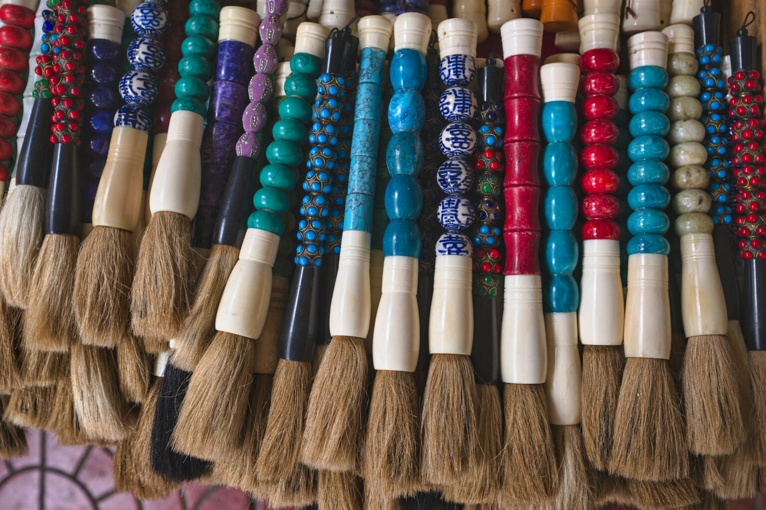 Pincéis de caligrafia com cabos de contas coloridas: turquesa, vermelhas e de porcelana azul e branca