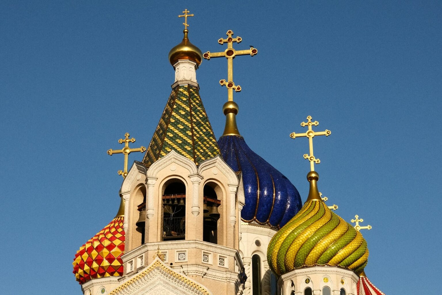 Cúpulas coloridas de uma igreja ortodoxa, em azul, verde, amarelo e vermelho, contra o céu azul