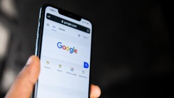 Mão segura smartphone no Google