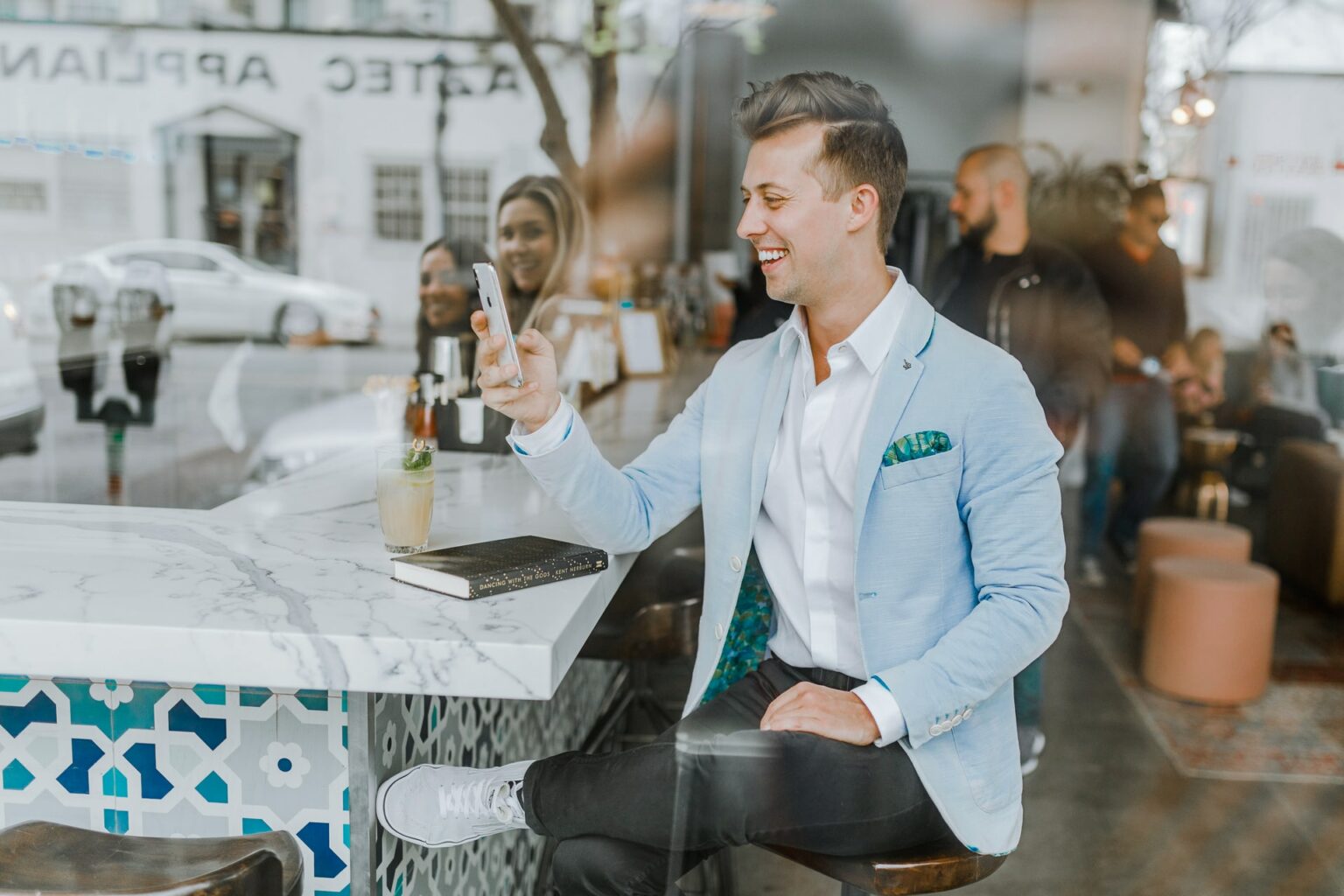 Tinder e Duolingo juntos para ensinar a paquerar em outros idiomas imagem destacada - homem sorrindo enquanto conversa no smartphone