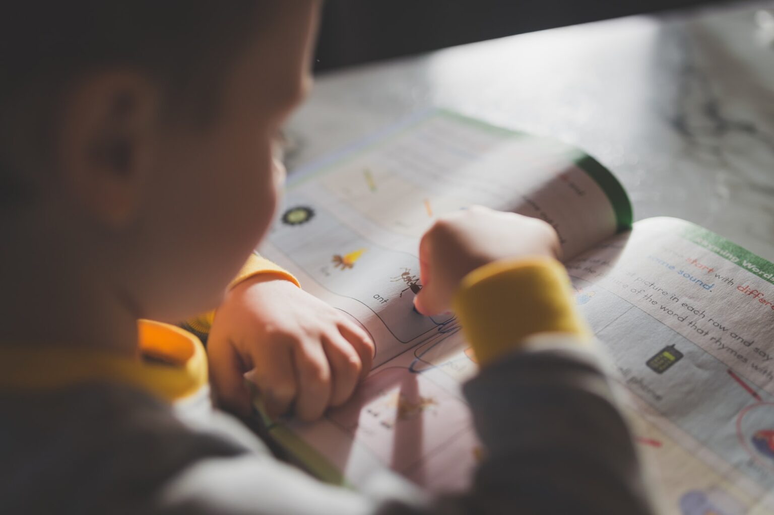 Qual é a melhor idade para aprender um idioma do zero? imagem destacada - menino lendo livro